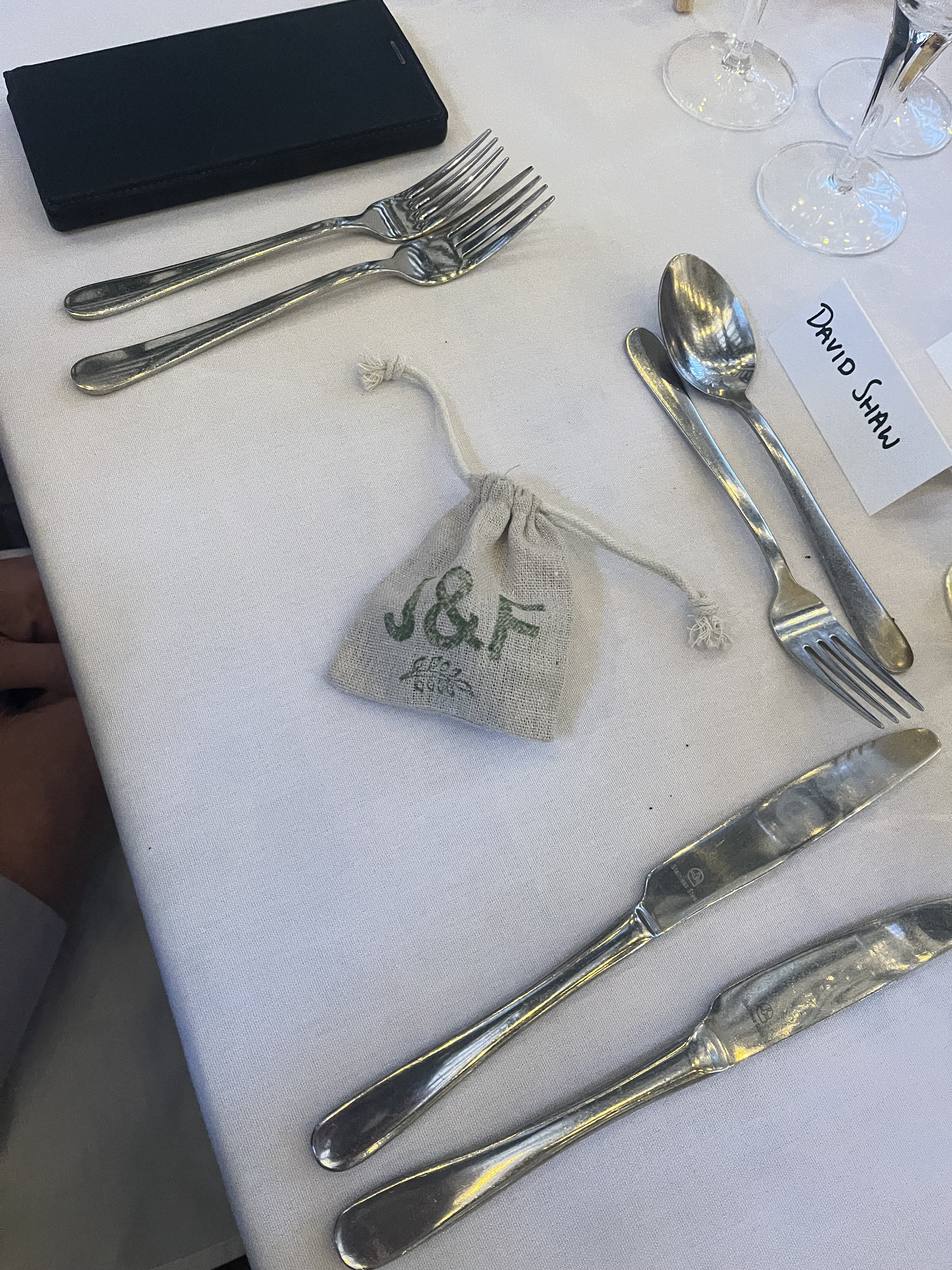 A small linen bag with the initials J & F in green.