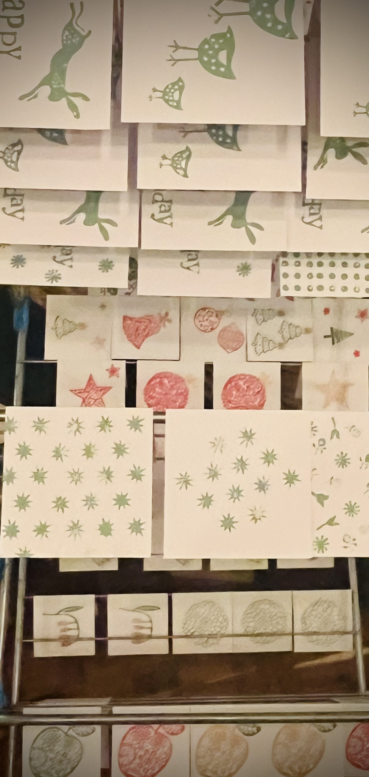 Christmas cards drying on a rack.