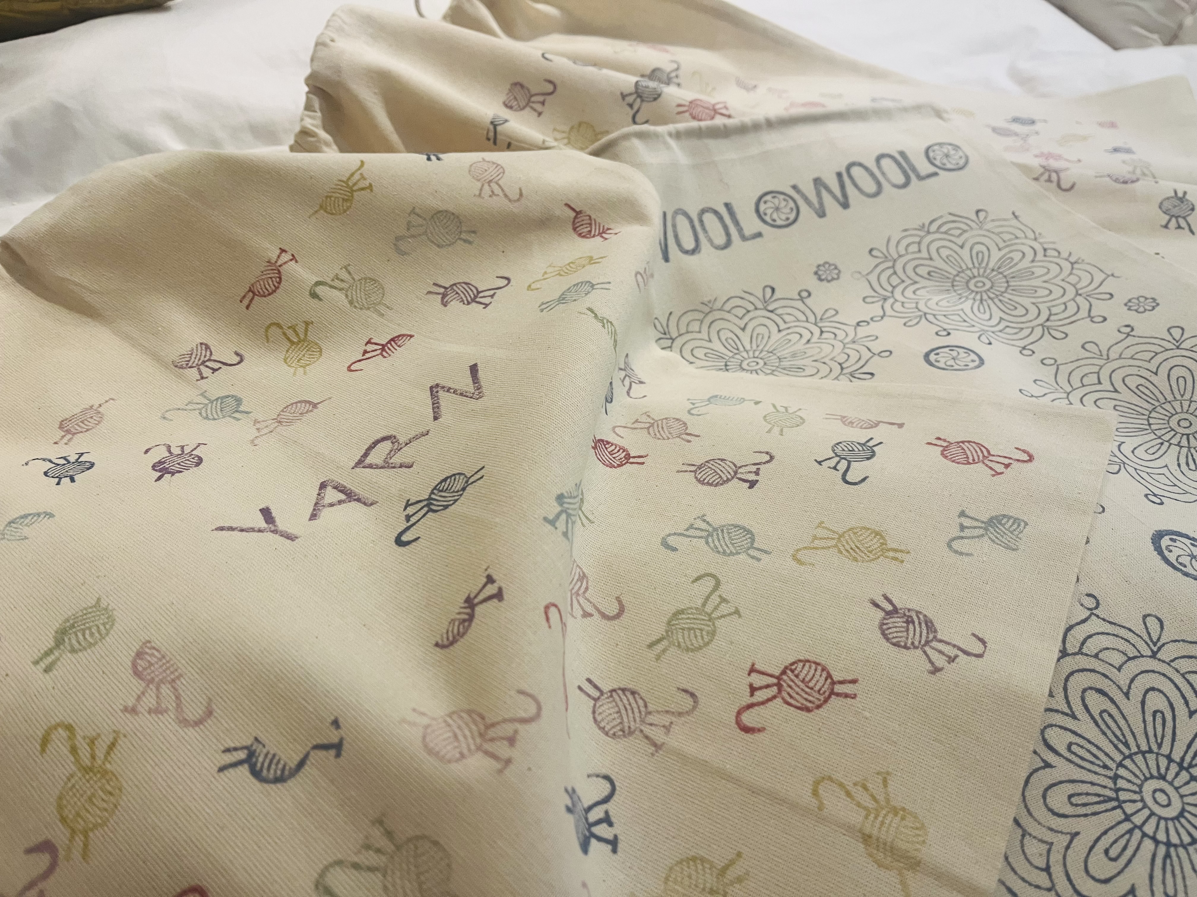 Yarn and wool craft bags with mini balls of wool and knitting needles in different colours.